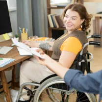 Woman in wheelchair reviews documents in office