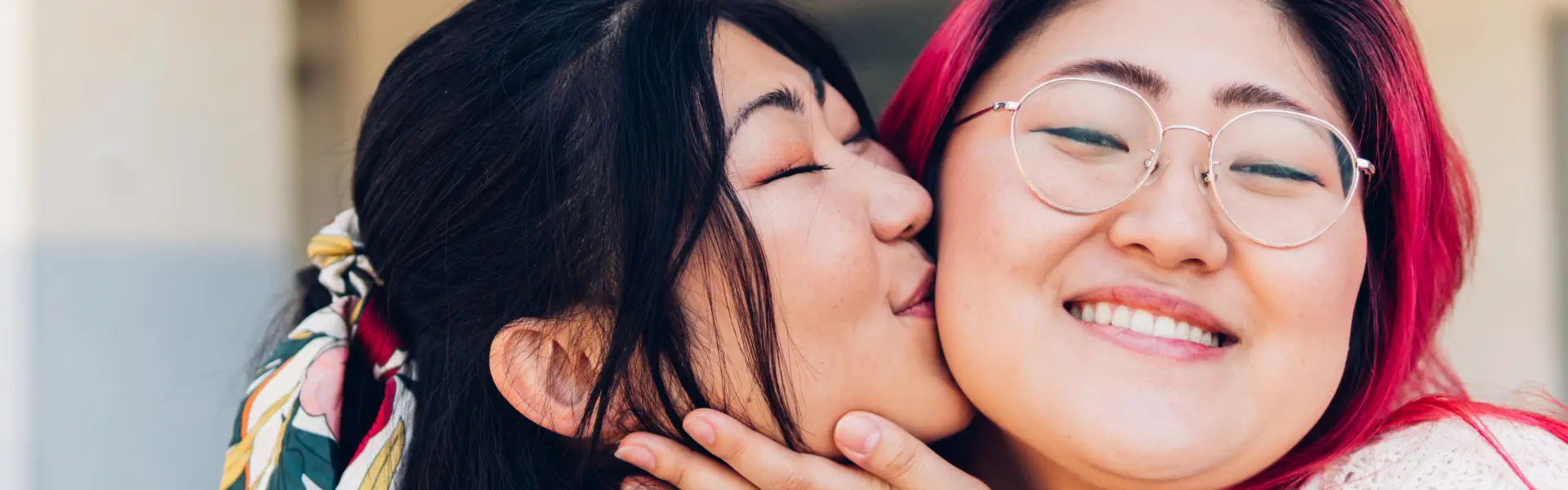 young woman kissing her friend